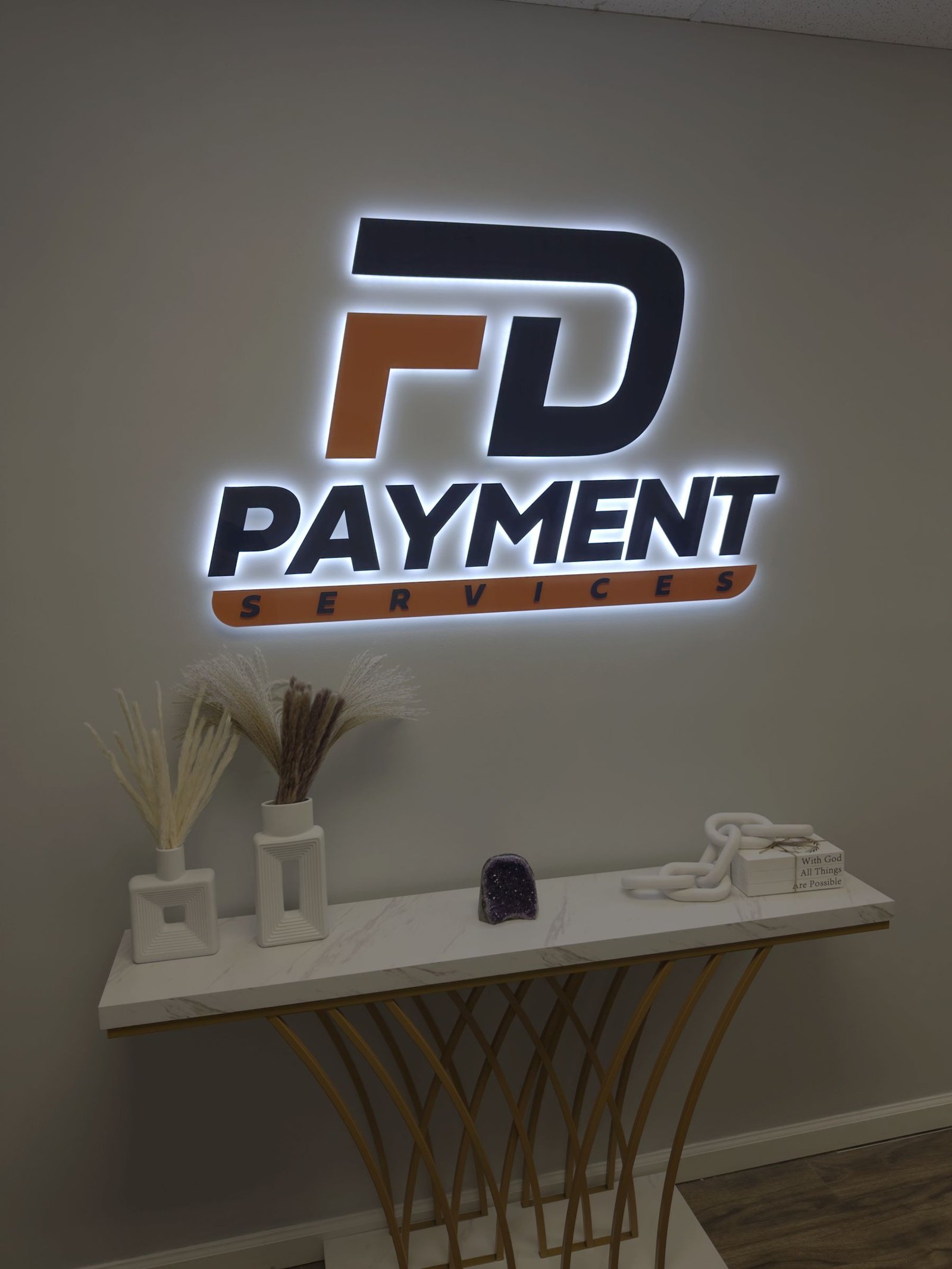Illuminated FD Payment logo sign on an office wall